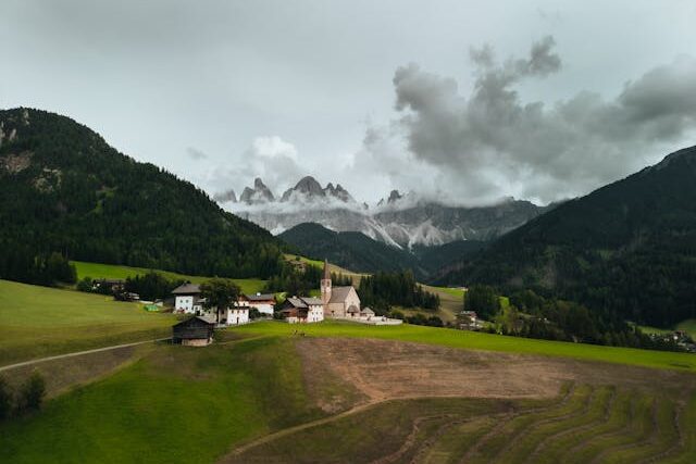 Villnös, Italy: A picturesque village nestled in the Italian Alps with dramatic mountain backdrop.