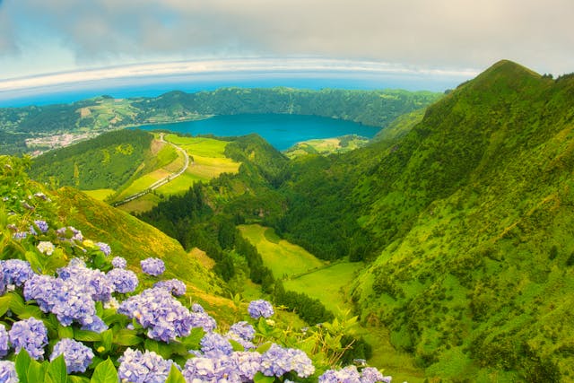 Ponta Delgada, Portugal: Breathtaking panoramic view of Sete Cidades in Azores with vibrant hydrangeas and lush green landscape.